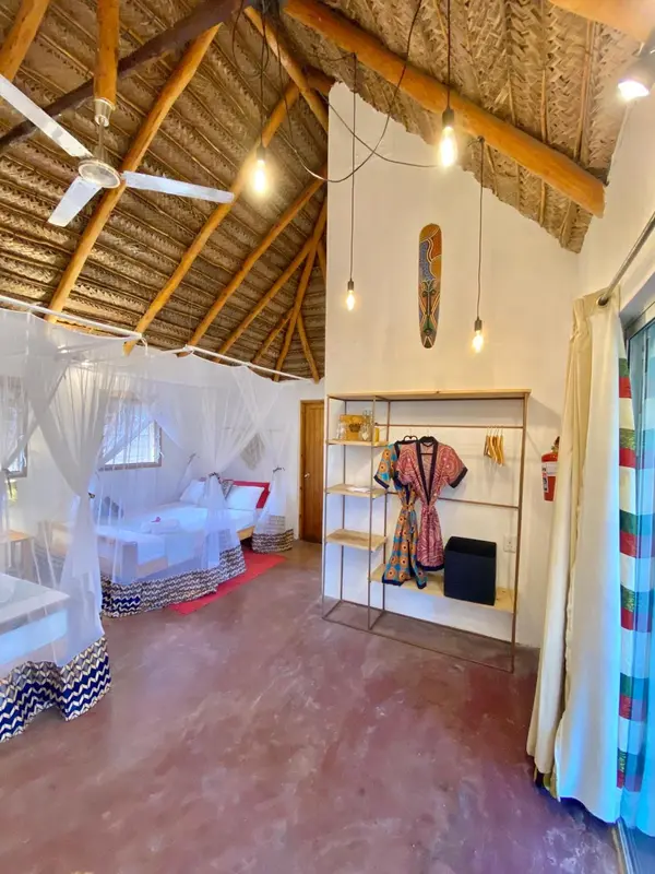 Une chambre lumineuse avec un lit à baldaquin et une décoration ethnique.