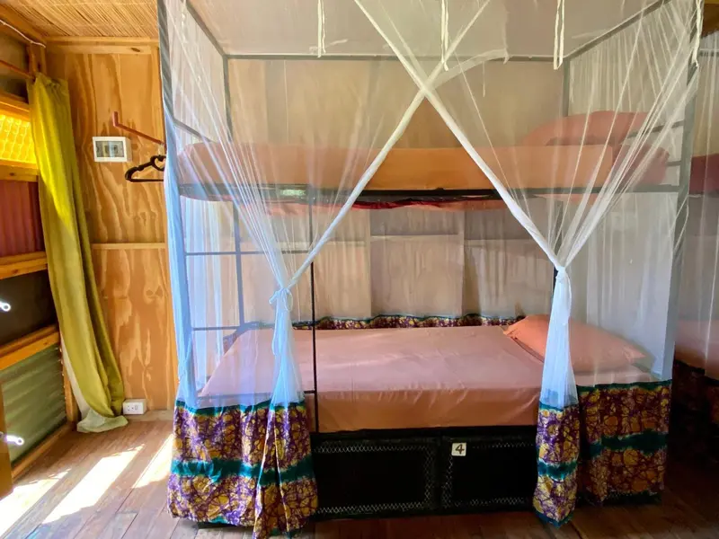 Lit superposé avec moustiquaire dans une chambre aux couleurs vives.