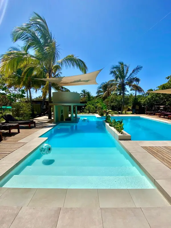 Une piscine rectangulaire bordée d'une terrasse ensoleillée avec des transats.