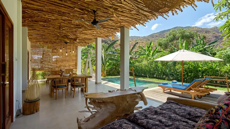 Terrasse ombragée avec mobilier de détente et piscine.