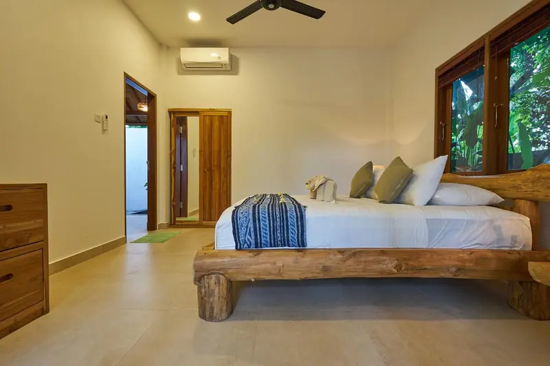 Une chambre lumineuse avec un grand lit et un accès à l'extérieur.