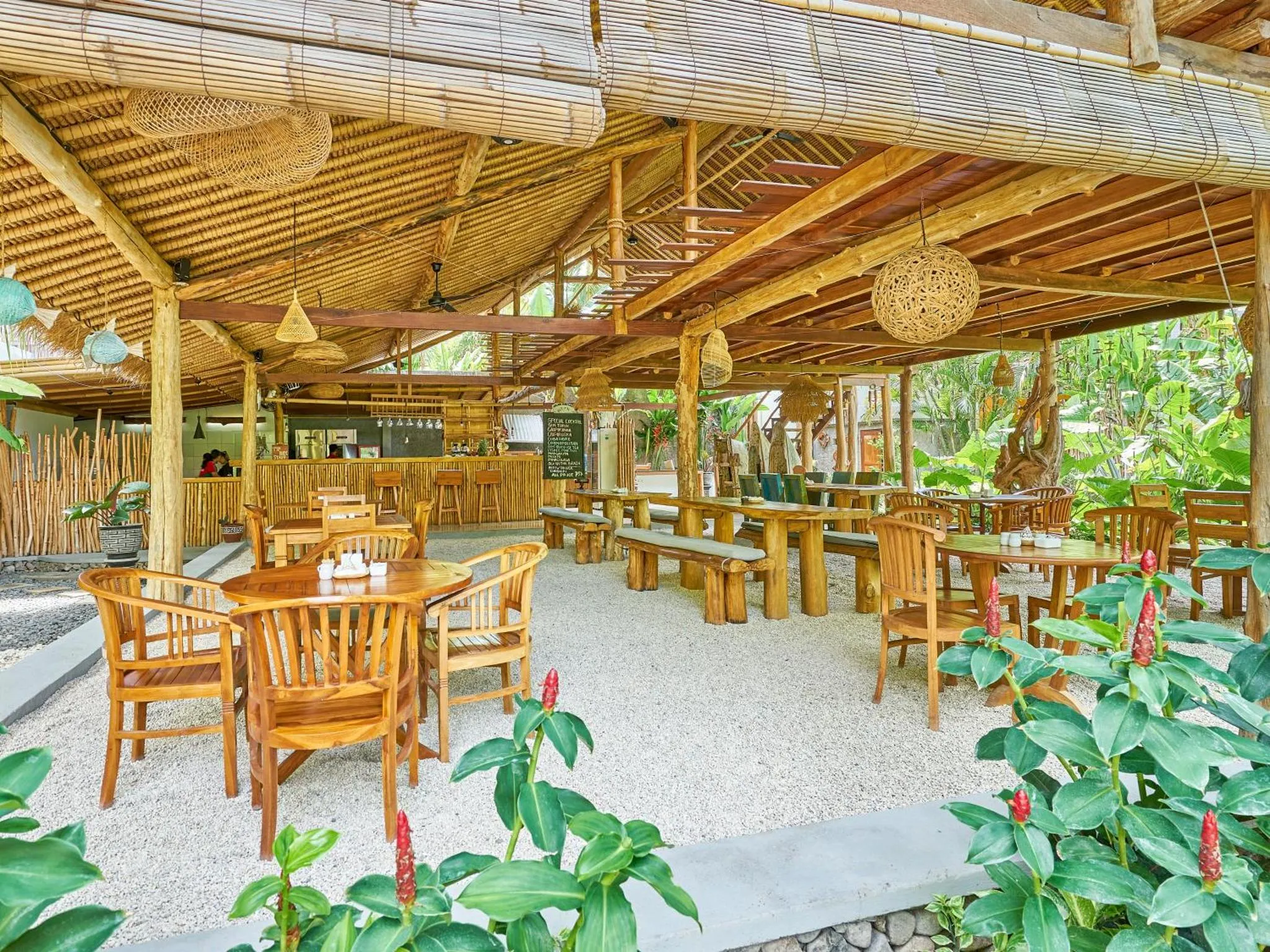 Une salle à manger extérieure en bois avec des tables et des chaises.