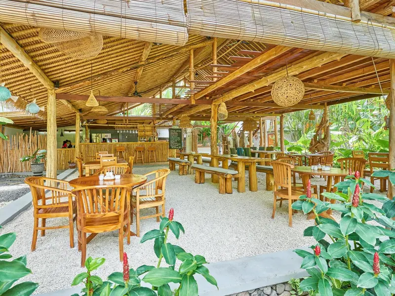 Une salle à manger extérieure en bois avec des tables et des chaises.