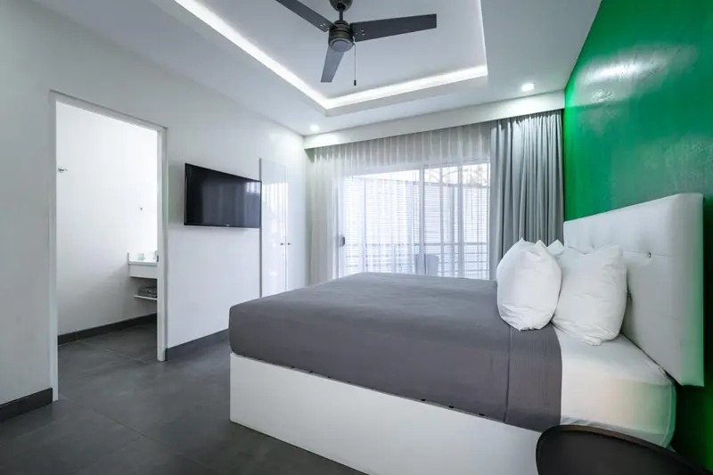 Une chambre lumineuse avec un grand lit et un accès à une terrasse.