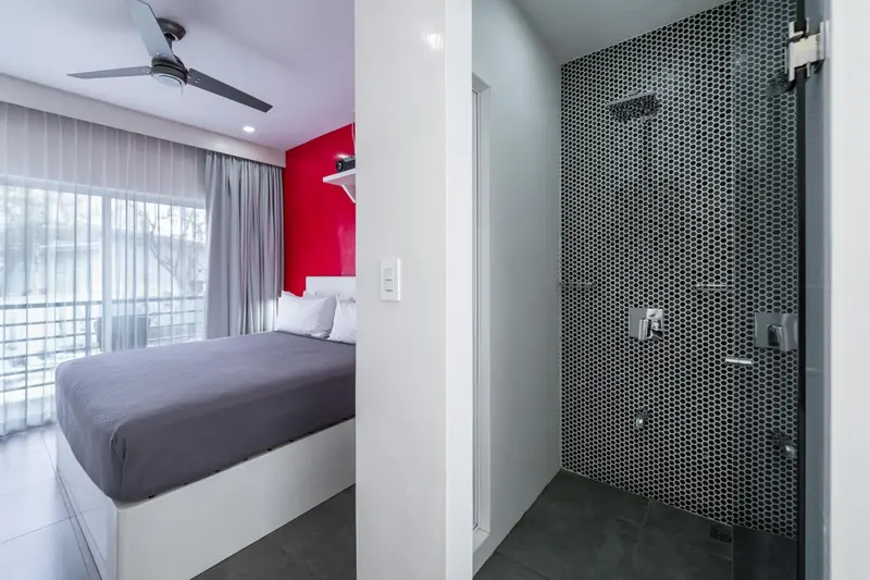 Une chambre moderne avec un lit et une salle de bain carrelée.