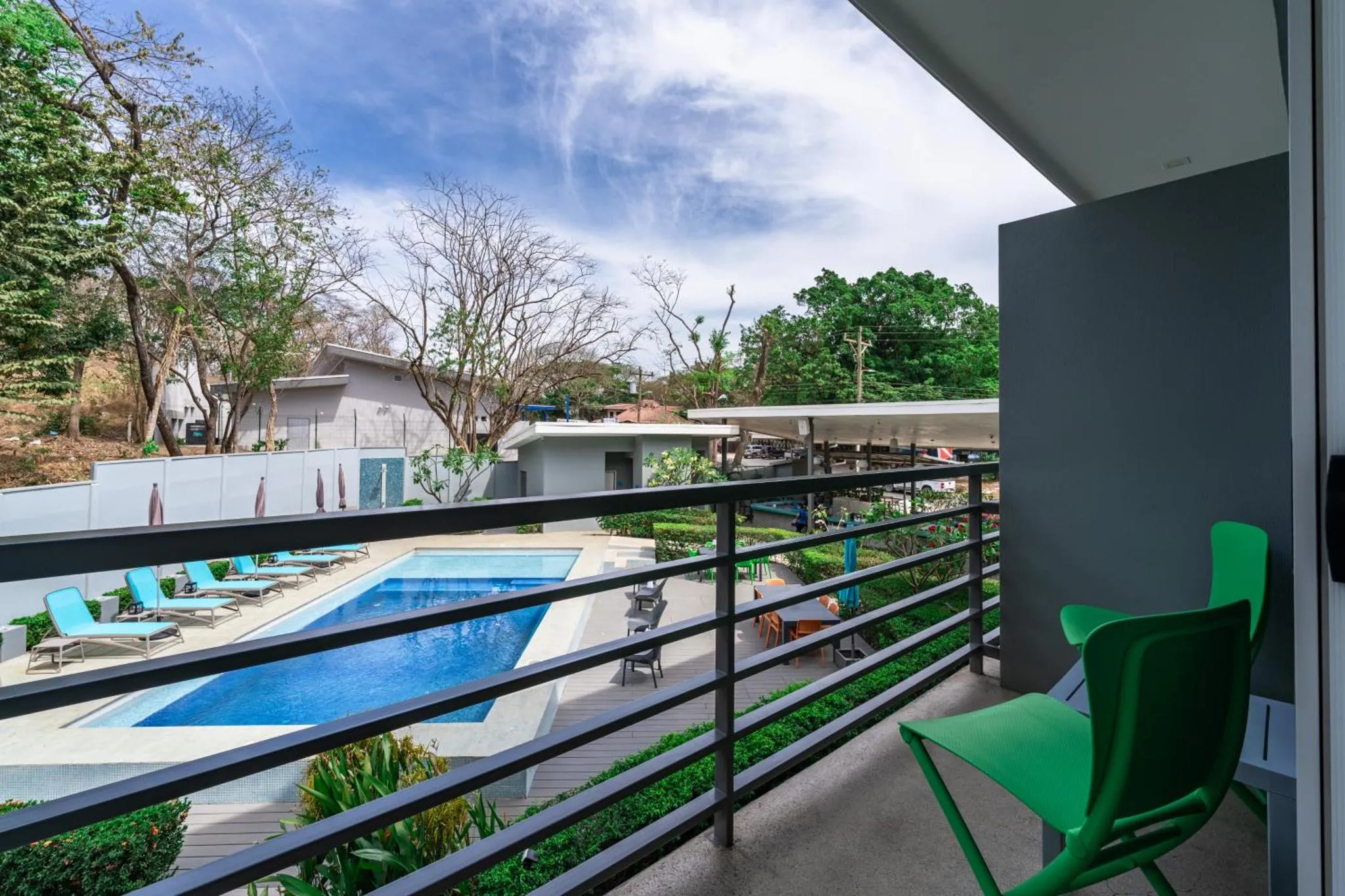 Terrasse avec vue sur une piscine et une végétation luxuriante.