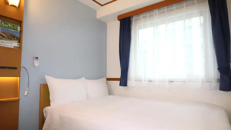 Une chambre lumineuse avec un lit simple près d'une fenêtre.