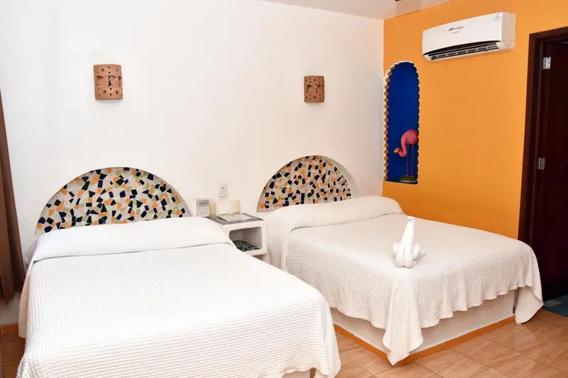 Chambre lumineuse avec deux lits simples et décoration colorée.