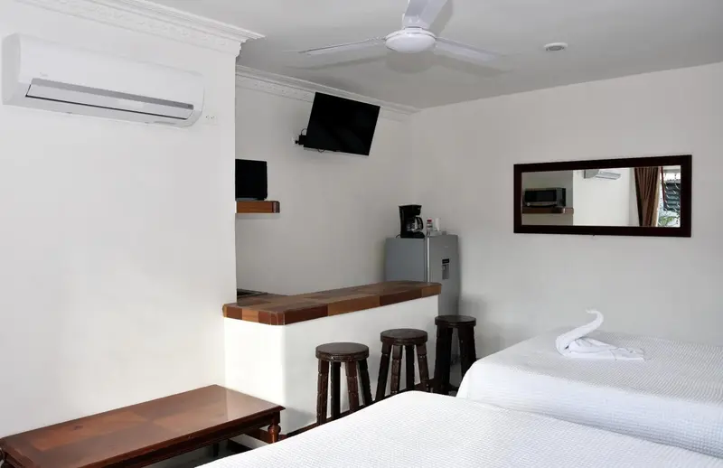 Une chambre lumineuse avec un coin repas et un réfrigérateur.