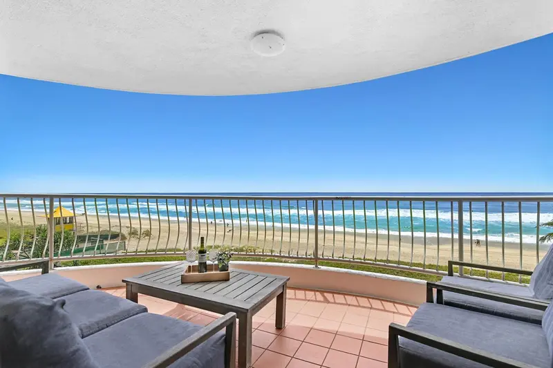 Vue sur la mer depuis une terrasse avec mobilier d'extérieur.