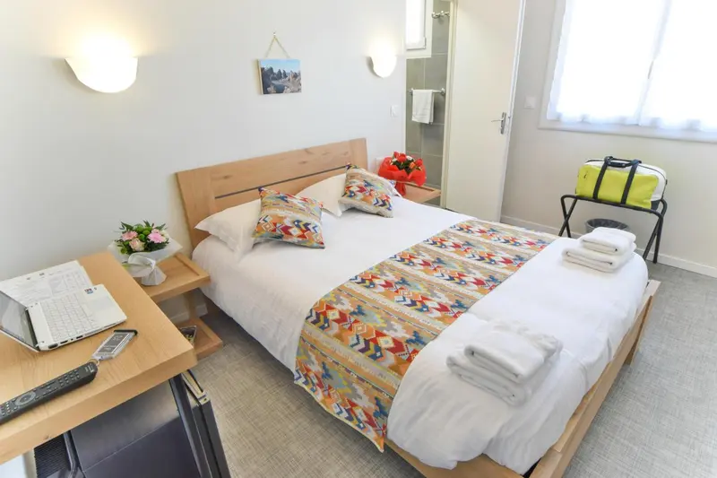 Une chambre lumineuse avec un lit double et une décoration colorée.