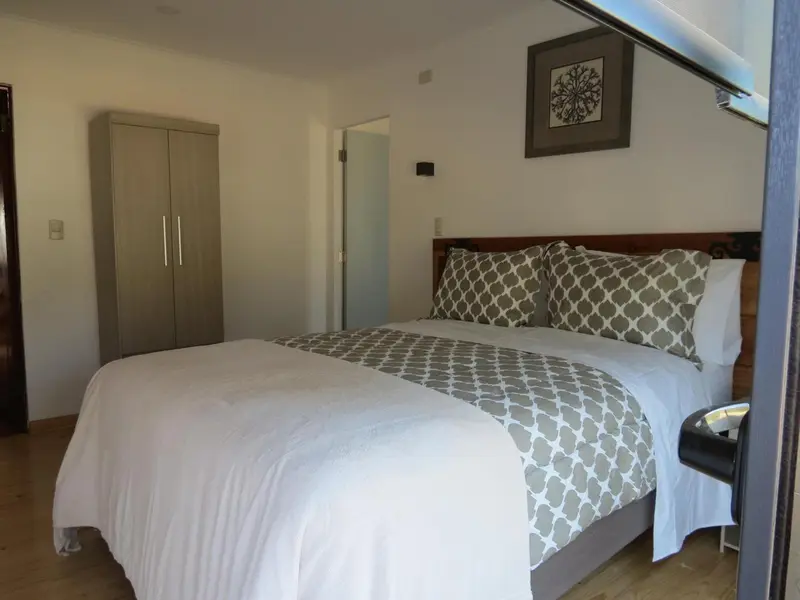 Une chambre lumineuse avec un grand lit et une décoration sobre.
