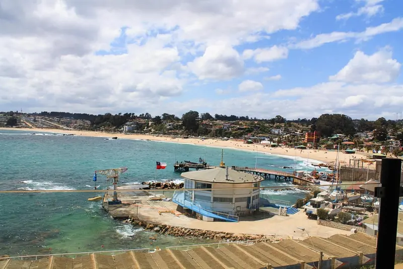 Vue aérienne d'une plage et d'une construction au bord de l'eau.
