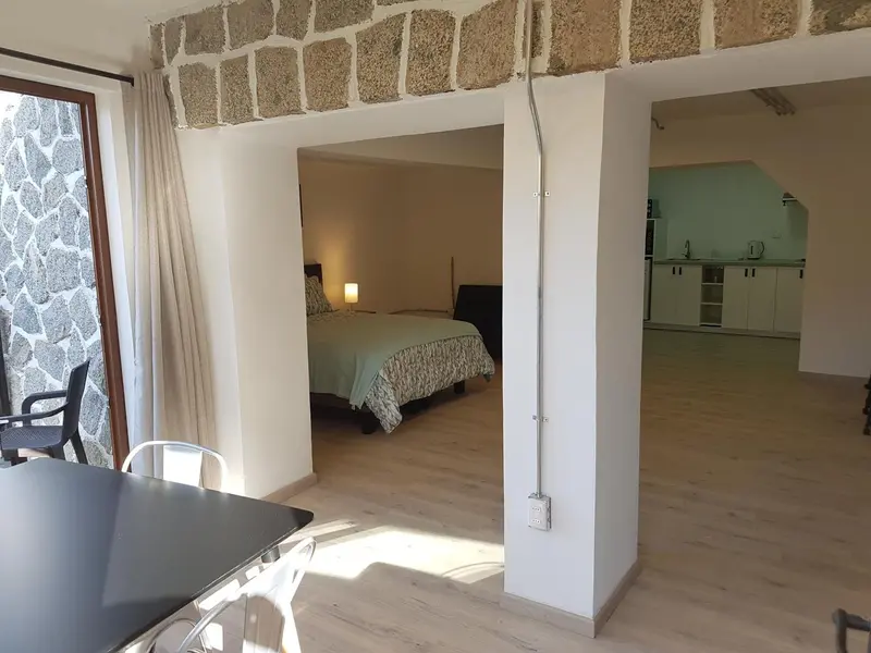 Une chambre lumineuse s'ouvre sur un espace de vie avec une kitchenette.