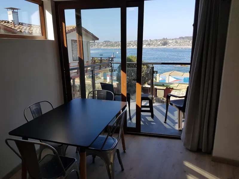 Une salle à manger lumineuse s'ouvre sur une terrasse avec vue sur la mer.