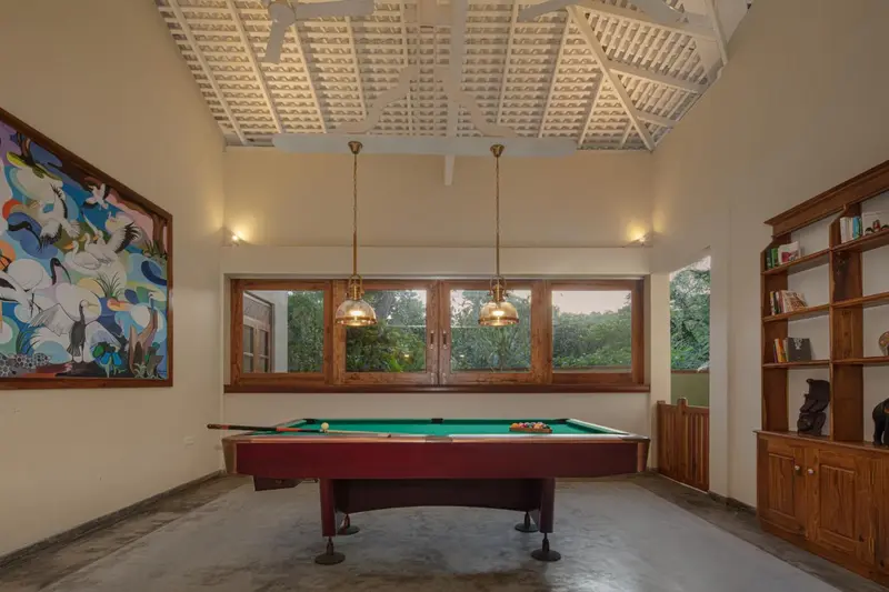 Une pièce lumineuse avec un billard et une bibliothèque.