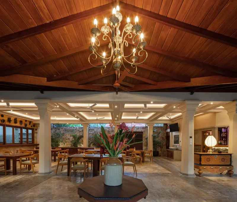 Une salle lumineuse avec un plafond en bois et un lustre central.