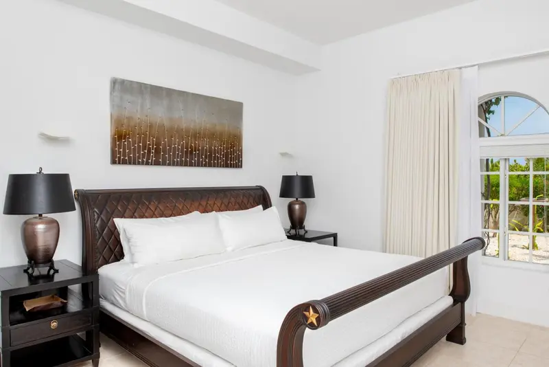 Une chambre lumineuse avec un grand lit et des lampes de chevet.