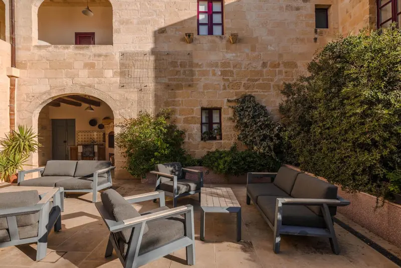 Cour intérieure aménagée avec des canapés et des fauteuils.