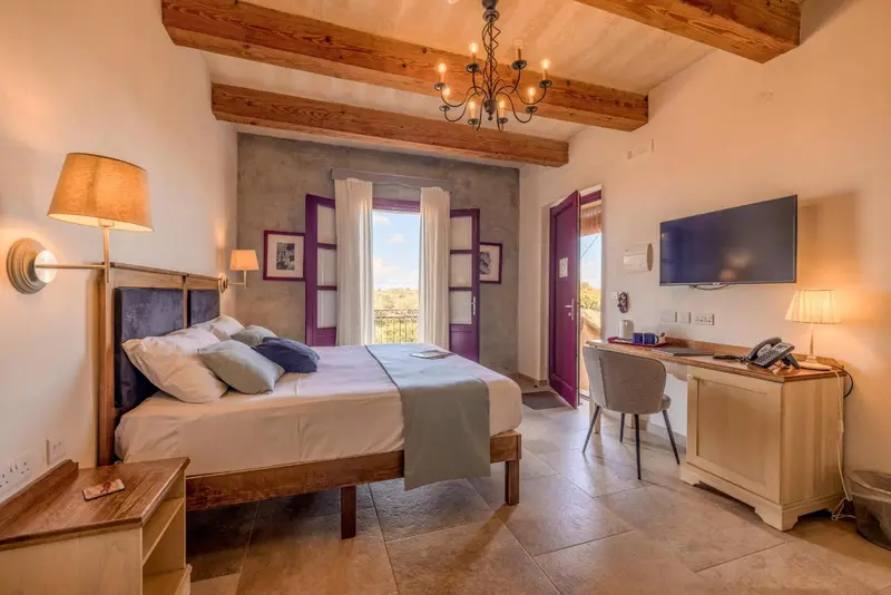 Chambre lumineuse avec lit double et bureau.