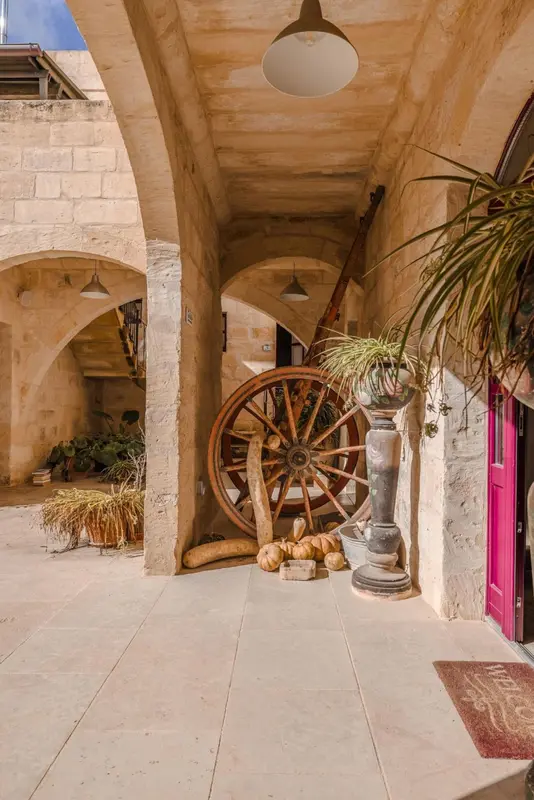 Une cour intérieure avec des arches et une grande roue en bois.