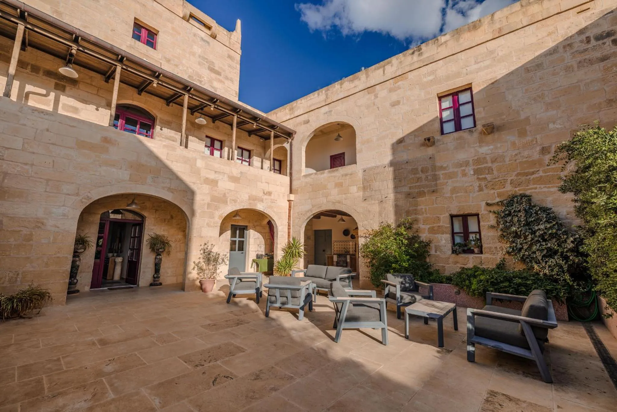Cour intérieure d'un bâtiment en pierre avec des espaces de détente.