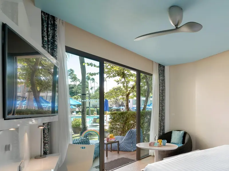 Une chambre lumineuse donne sur une terrasse et une piscine.