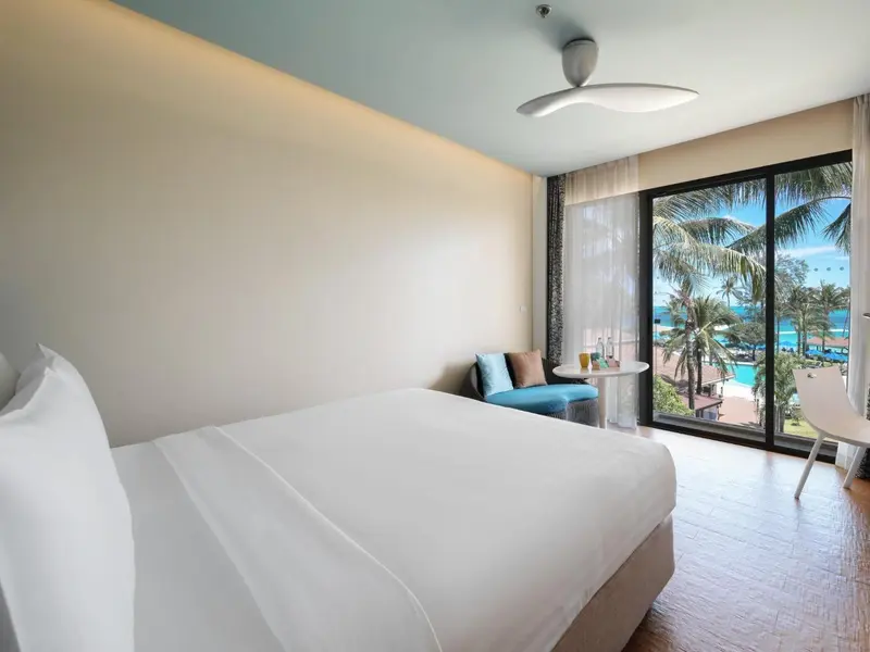 Une chambre lumineuse avec un grand lit et une vue sur la mer.