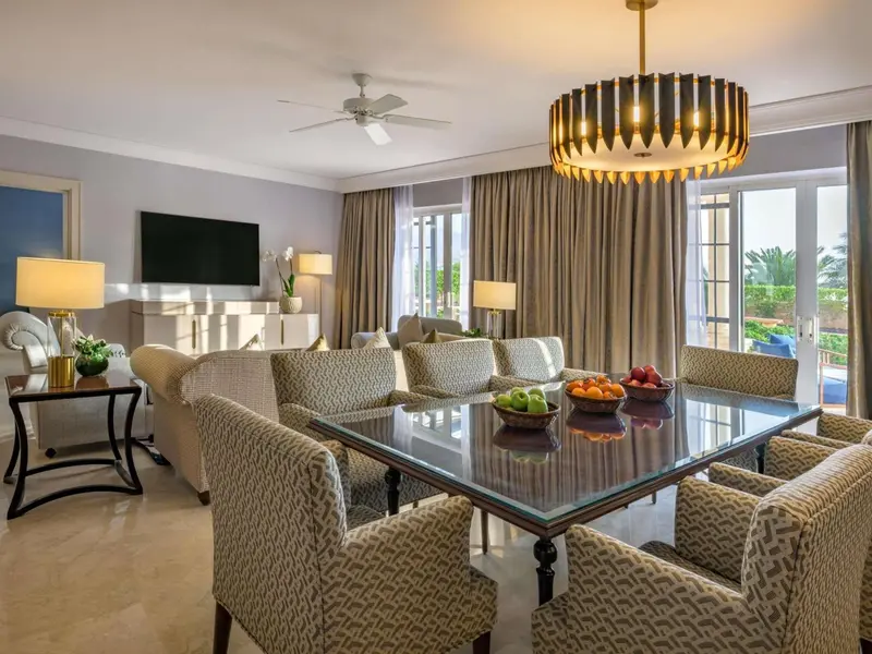Un salon lumineux avec un coin repas et des fauteuils confortables.