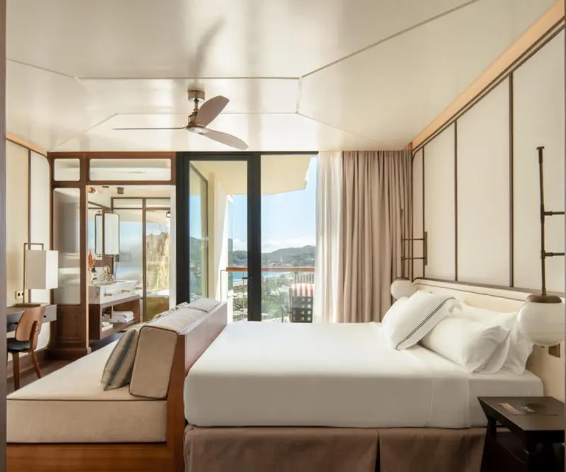 Une chambre lumineuse avec un grand lit et une vue sur la mer.