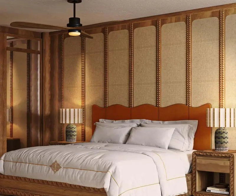 Un lit recouvert d'une courtepointe blanche se trouve dans une chambre décorée de bois et de rotin.