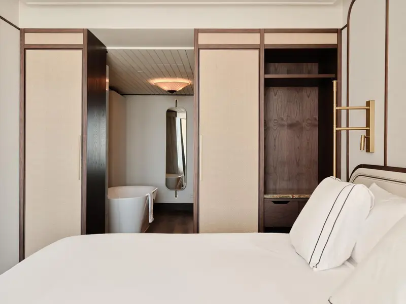 Une chambre lumineuse avec un lit et un espace baignoire.