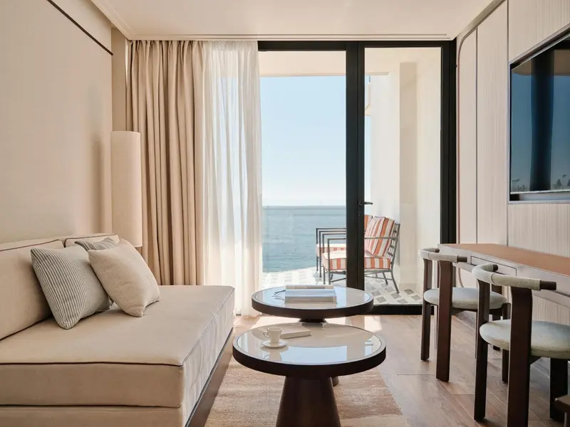 Espace de séjour lumineux avec canapé et table basse donnant sur une vue mer.