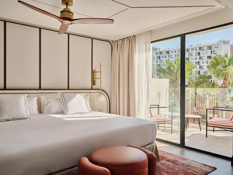 Une chambre lumineuse avec un grand lit et un accès à une terrasse.