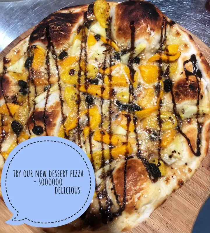 Une pizza dessert est présentée sur une planche à découper en bois.