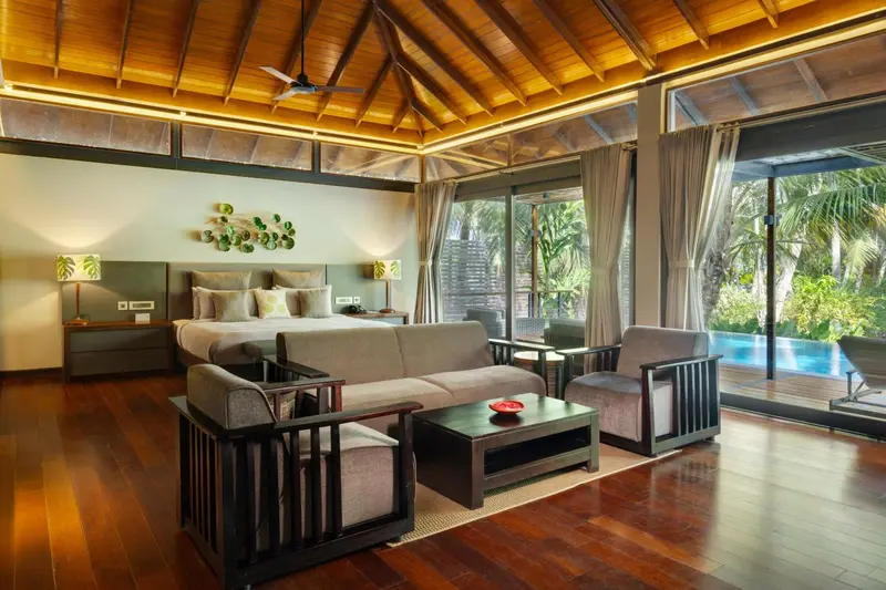 Espace de vie intérieur avec canapé, fauteuils et lit.