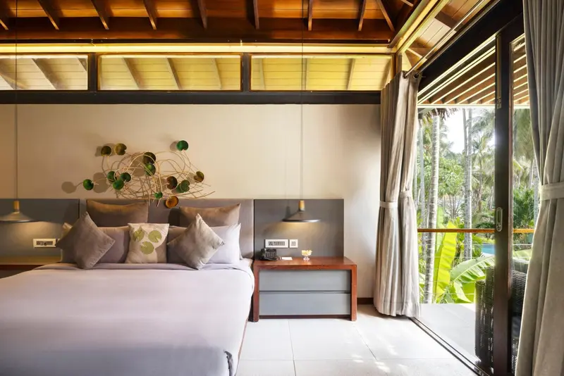 Une chambre lumineuse avec un grand lit et un accès à une terrasse.