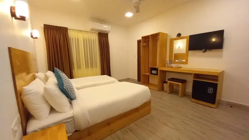 Une chambre lumineuse avec deux lits simples et un bureau.