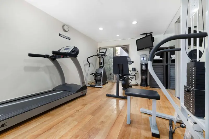 Une salle de sport lumineuse avec des équipements de musculation et de cardio.