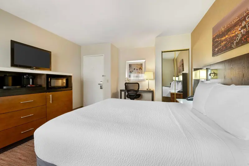 Une chambre d'hôtel lumineuse avec un grand lit et un espace de travail.
