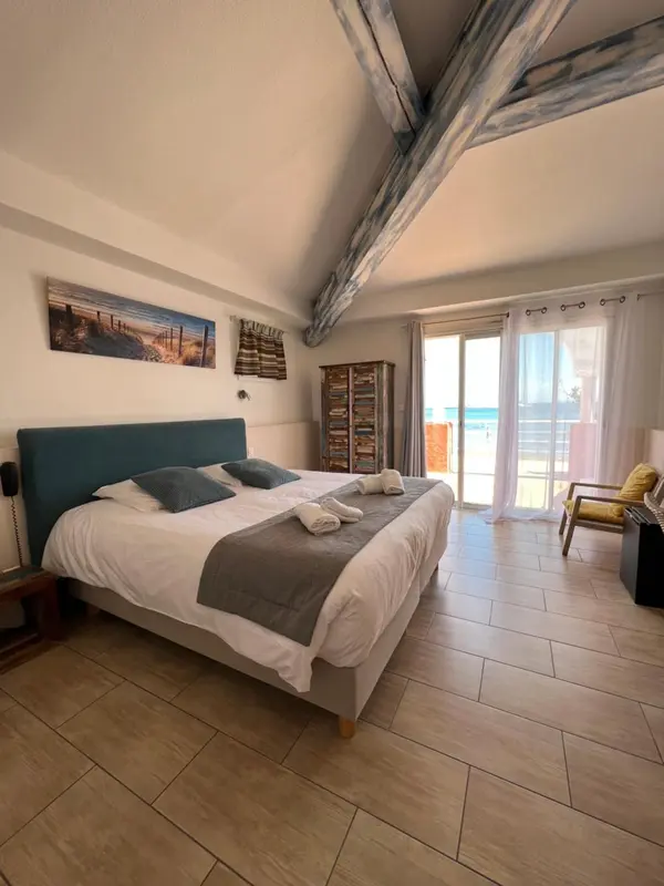 Une chambre lumineuse avec un grand lit et une vue sur la mer.