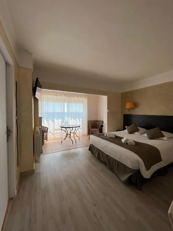 Une chambre lumineuse avec un grand lit et un accès à une terrasse.
