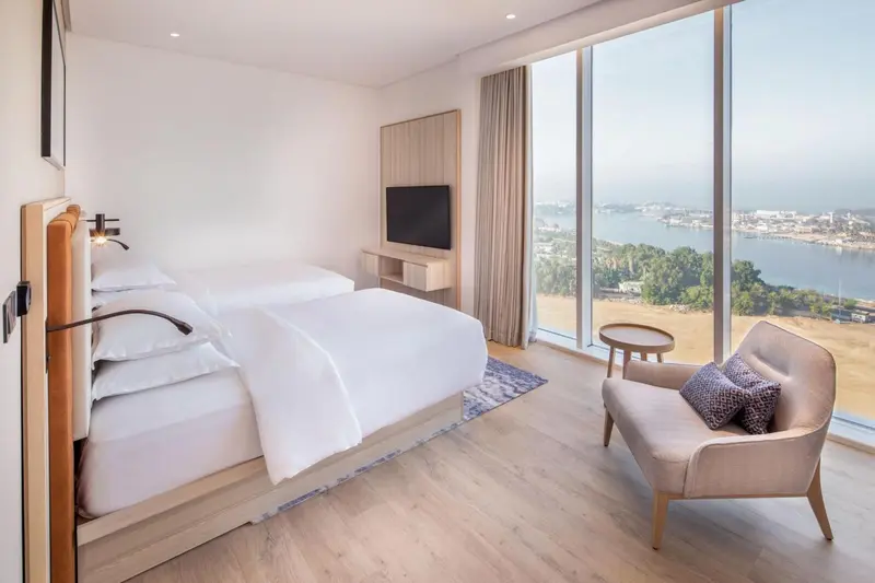 Une chambre lumineuse avec un grand lit et une vue sur la mer.
