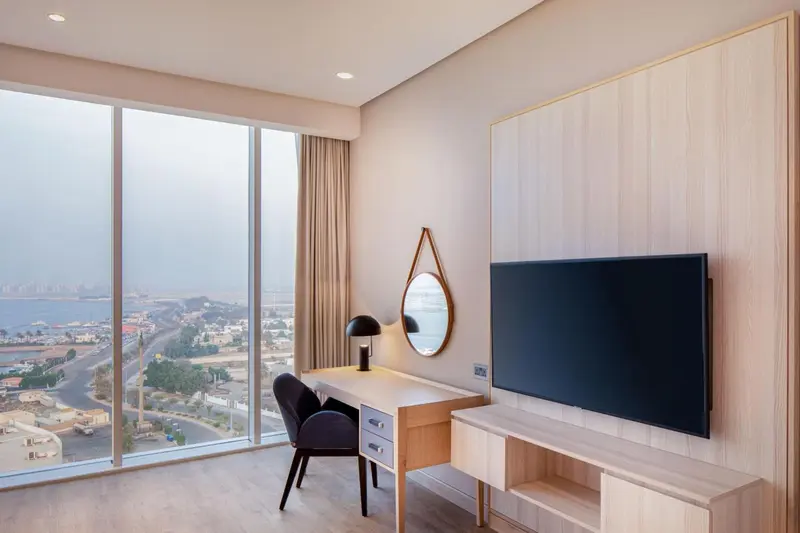 Une chambre lumineuse avec un bureau et une vue sur la mer.