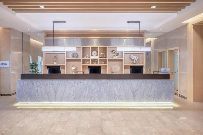 Un comptoir d'accueil moderne avec un éclairage lumineux et des éléments décoratifs.