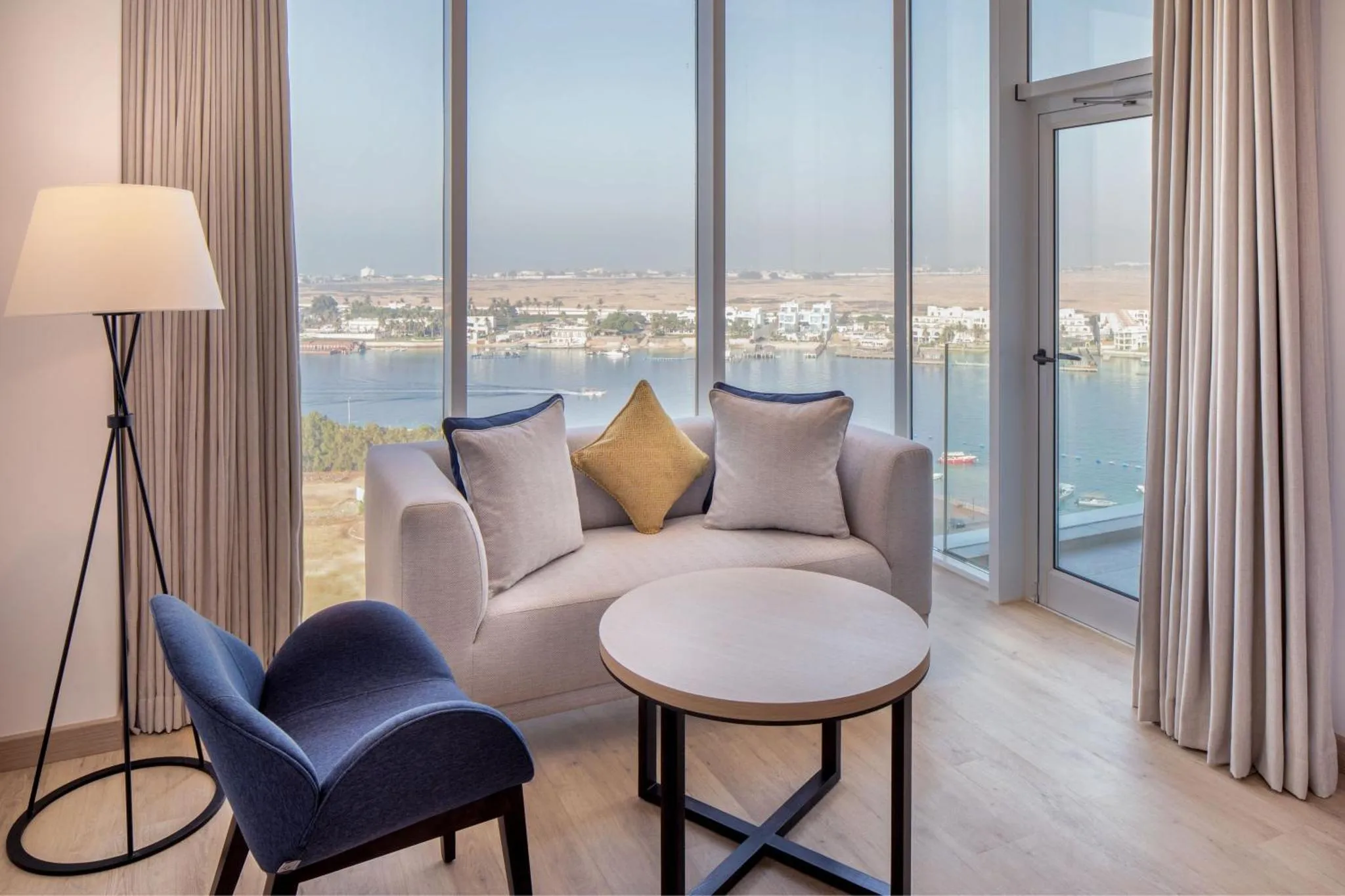 Un salon confortable avec canapé et fauteuils offre une vue sur la mer.