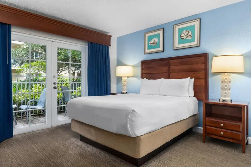 Une chambre lumineuse avec un grand lit et un accès à une terrasse.