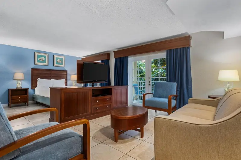 Une chambre lumineuse avec un lit, un coin salon et une vue sur l'extérieur.