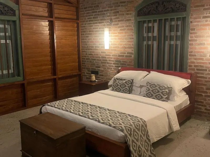 Une chambre lumineuse avec un lit recouvert d'une courtepointe à motifs.