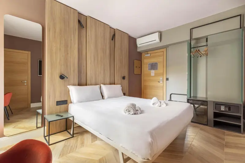 Une chambre d'hôtel moderne avec un grand lit blanc et des décorations soignées.